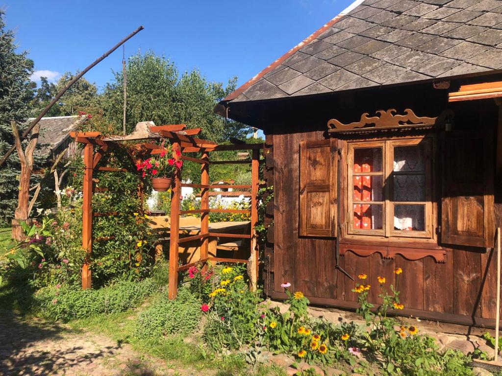 mały drewniany dom z oknem i ogrodzeniem w obiekcie Letnisko Sikory w mieście Sikory