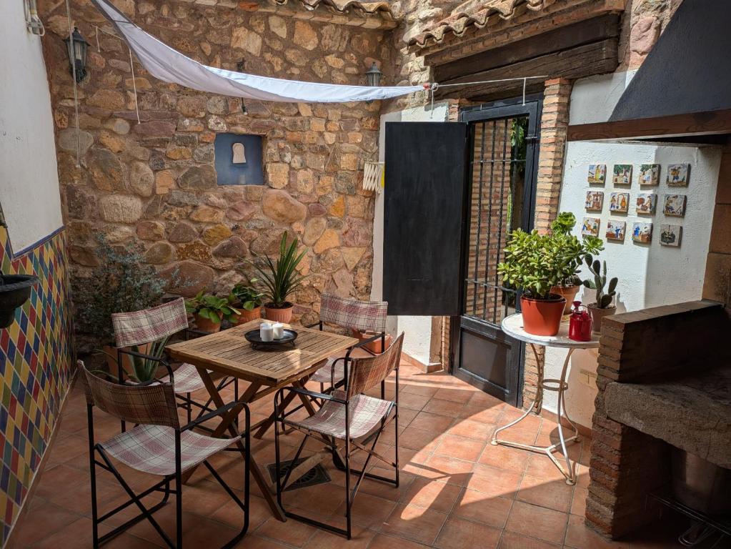 a patio with a wooden table and chairs and a fireplace at Ca'n Josep in Segorbe
