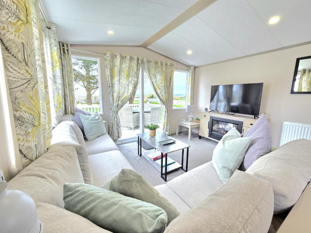 ein Wohnzimmer mit Sofa und Fernseher in der Unterkunft Cornwall Caravan Retreat, Near Perranporth, 3 Bedroom in Newquay