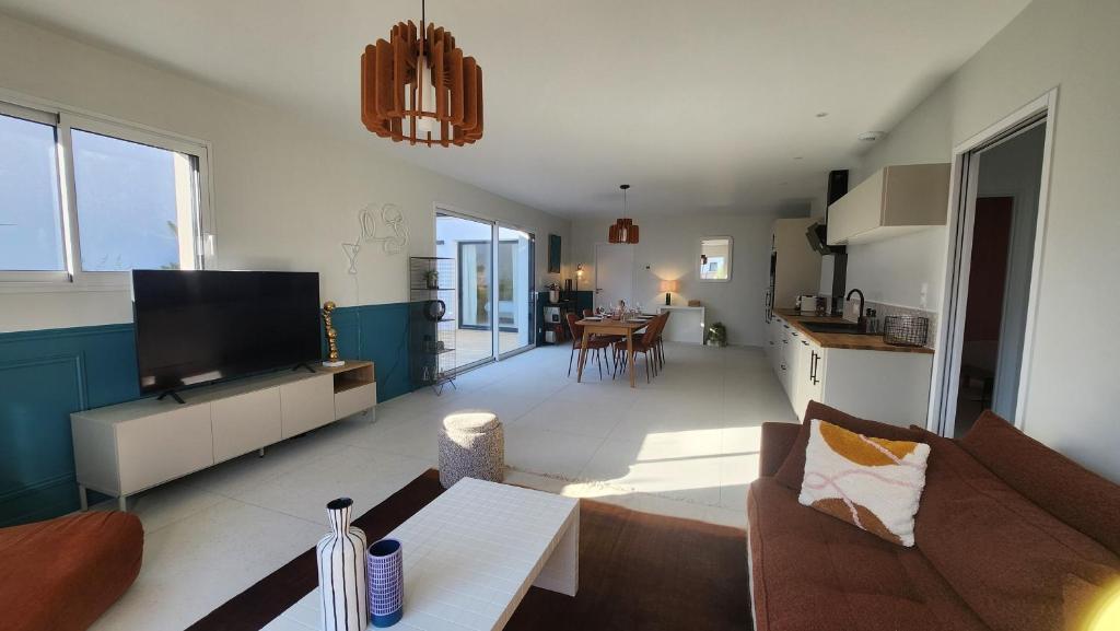 un salon avec un canapé et une télévision dans l'établissement La Pétillante, à Vaux-sur-Mer