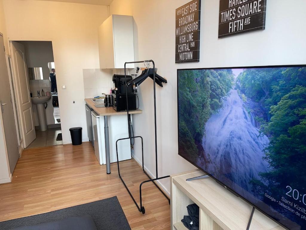 - un salon avec une grande télévision à écran plat et une caméra dans l'établissement Studio Hôtel Villeurbanne Charpenne 3, à Villeurbanne