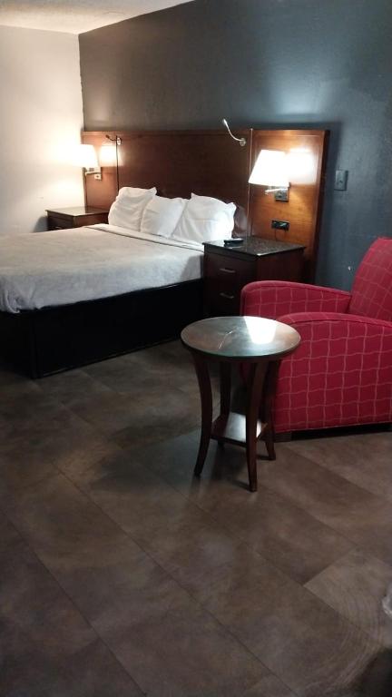 a hotel room with a bed and a red couch at King Bed Hotel Room 214 in Jackson