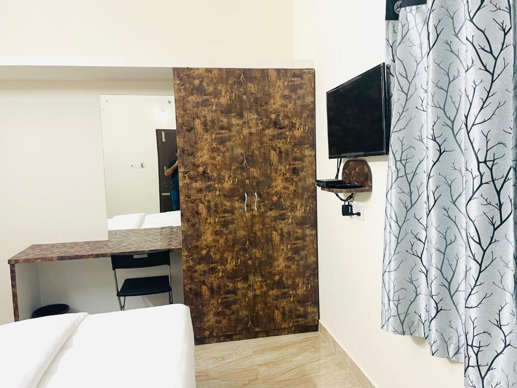 TV a/nebo společenská místnost v ubytování Pearl Stays, Tirupati - Very convenient for the people coming from Bangalore and Chennai - You can skip city traffic while reaching any temple in Tirupati - Covered Parking - 24hrs Front Desk and Hot Water - Free WiFi - Flexible Checkin-in Check-out times