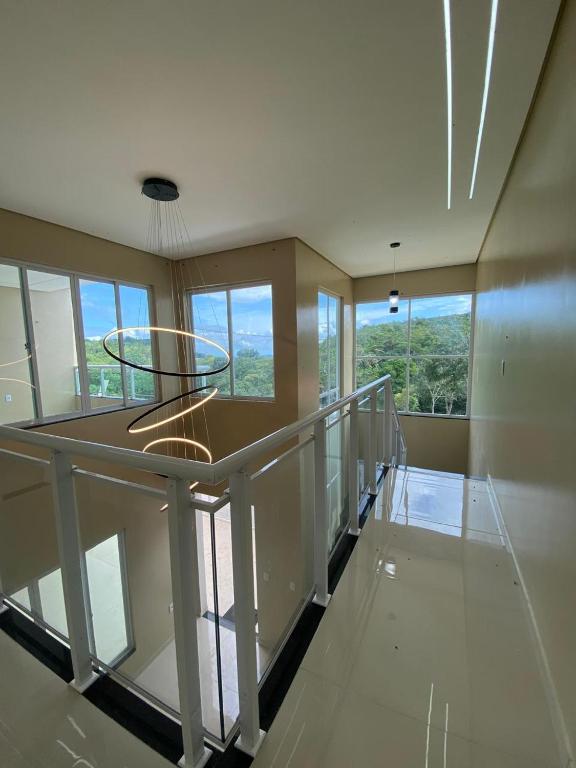 an empty room with a balcony with windows and a staircase at Casa Essenza in Mulungu