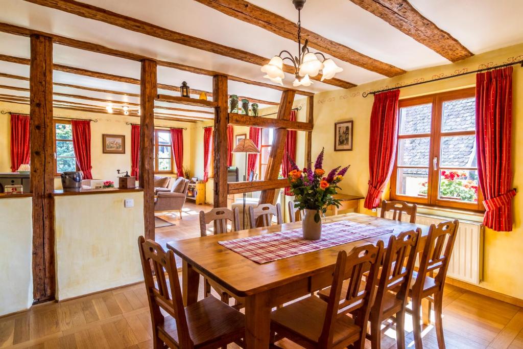 uma sala de jantar com uma mesa de madeira e cadeiras em Maison Gîte Au Tonnelier em Hunawihr