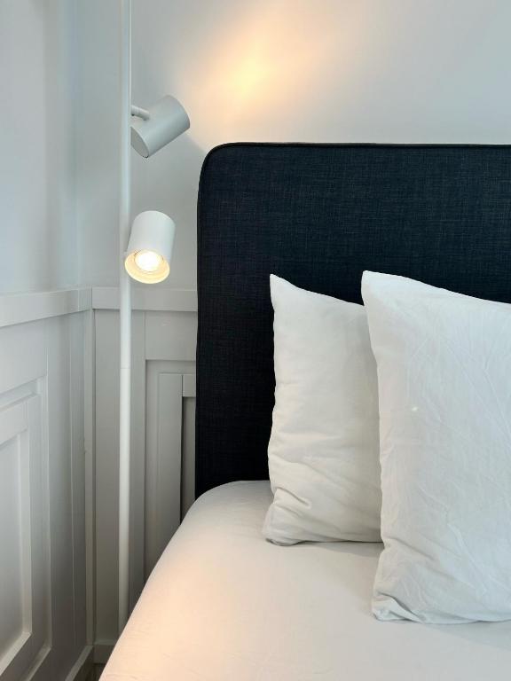 a bed with a black headboard and white pillows at Boulevard Lisbon Prime Suite in Lisbon