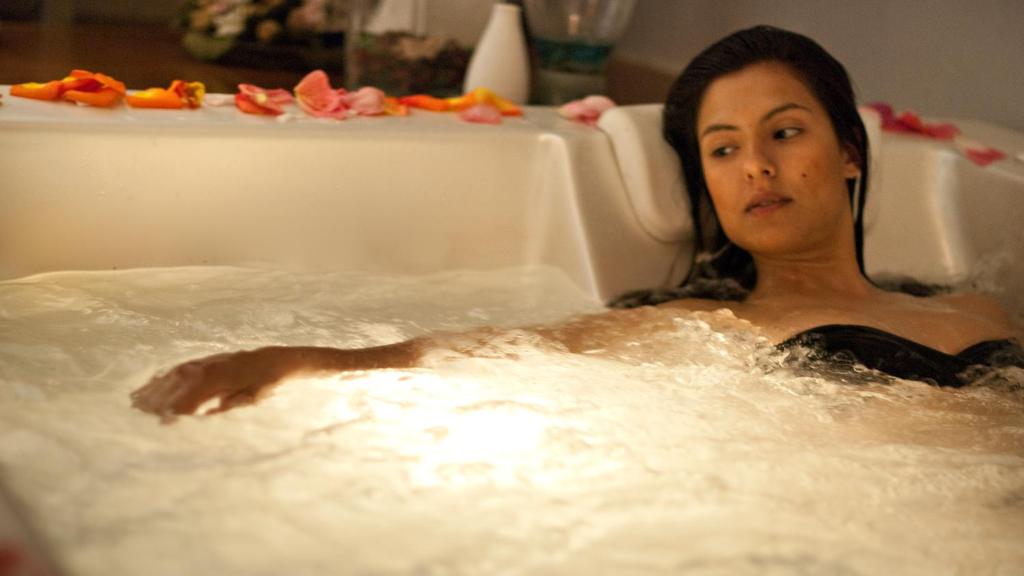 a woman is sitting in a bath tub at Albergo 'La Vigna' in Procida