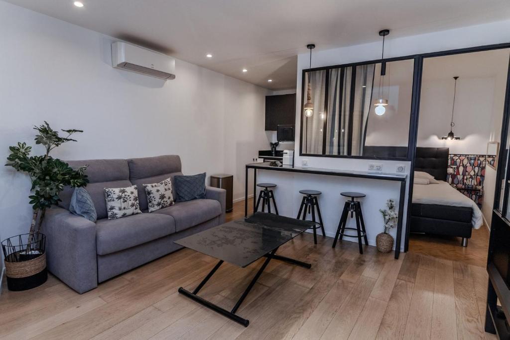 un salon avec un canapé et une table dans l'établissement Merveilleux appartement - Proche de la Croisette !, à Cannes