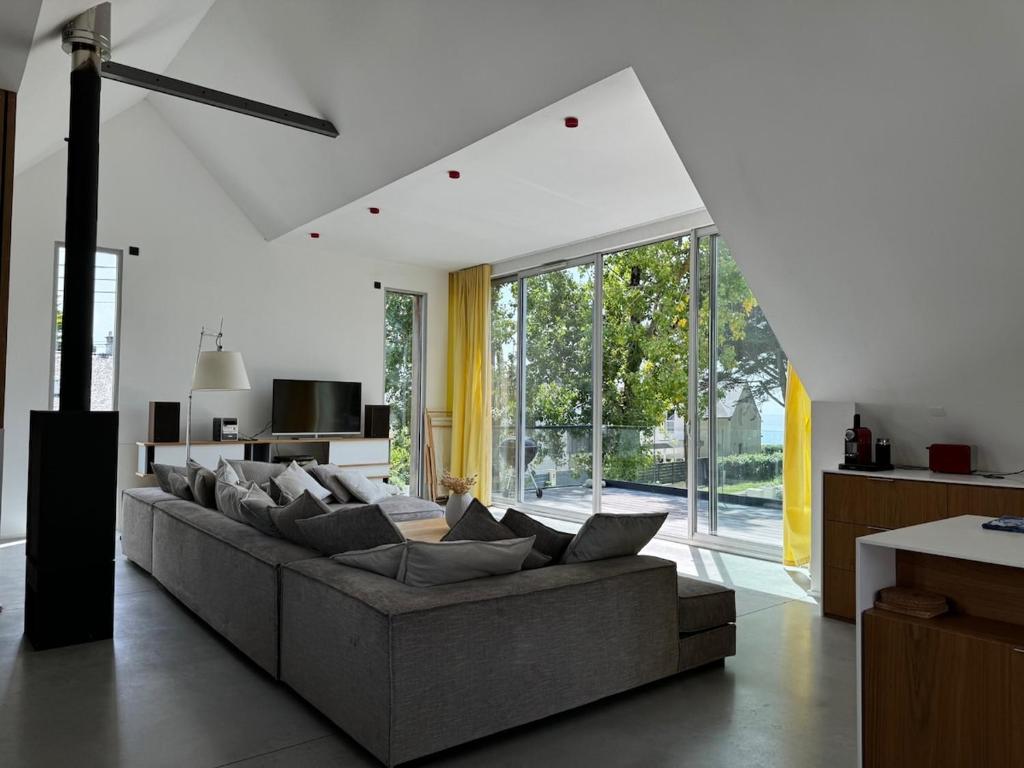 un salon avec un canapé et une grande fenêtre dans l'établissement Villa contemporaine vue mer - Maison d'architecte, au Pouliguen