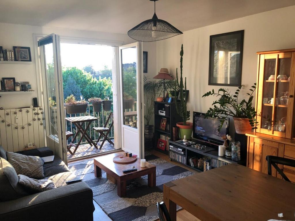 un salon avec un canapé et une table dans l'établissement Appartement plein centre avec place de parking, à Fougères