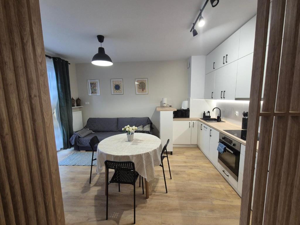 a kitchen and living room with a table and chairs at Torowa 2a Apartamenty El-Bema in Biała Podlaska