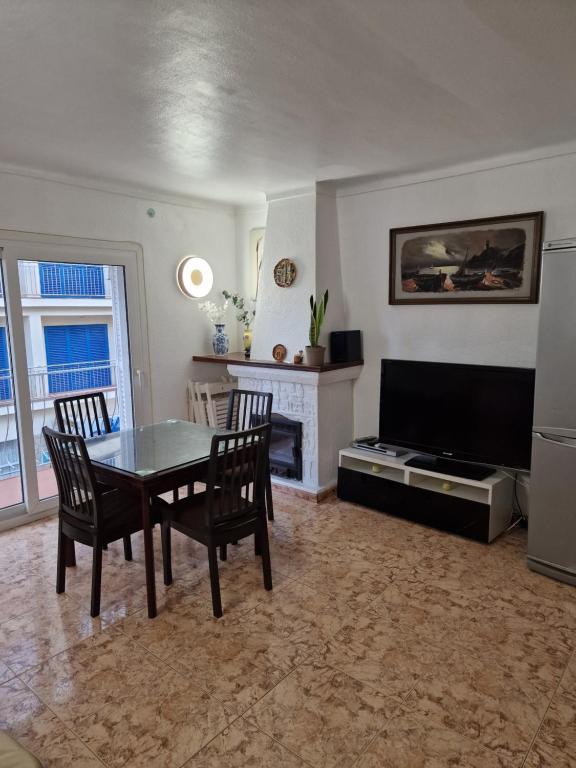 a living room with a table and chairs and a television at SunandSea in L'Estartit