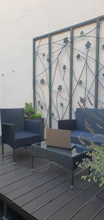 a patio with two chairs and a table and a wall at DM apartman Beograd in Vračar (historical)
