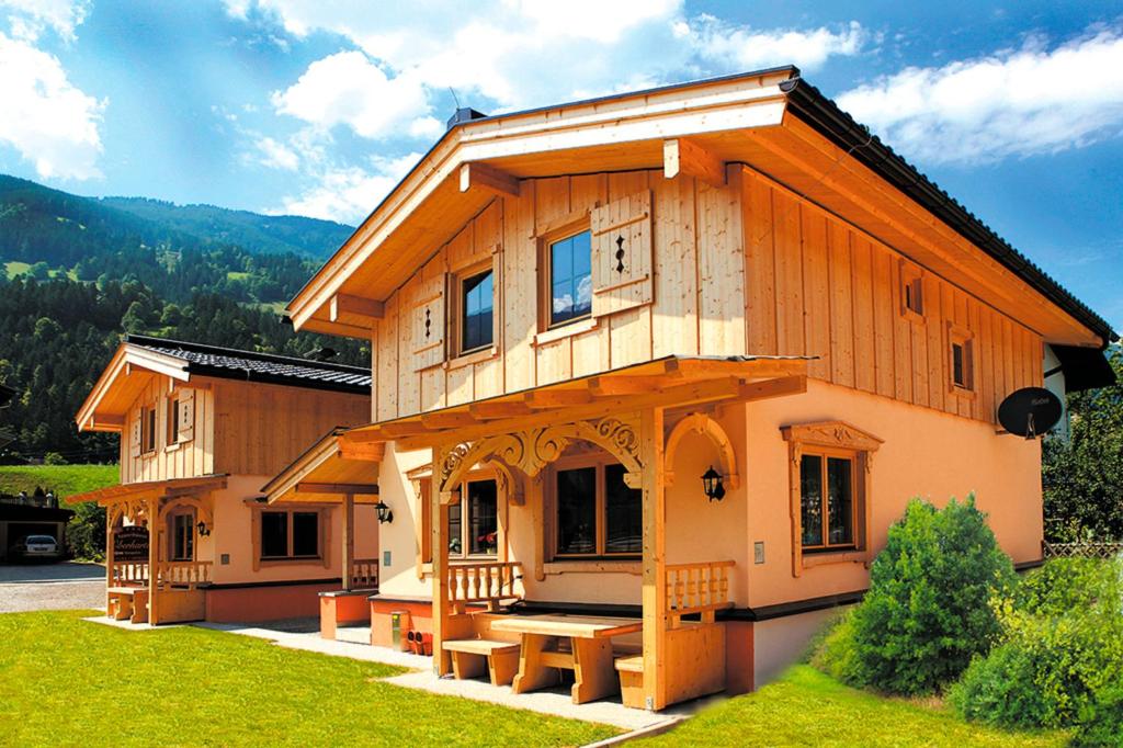 a large wooden house with benches in front of it at Ferienhaus Eberharter in Schwendau