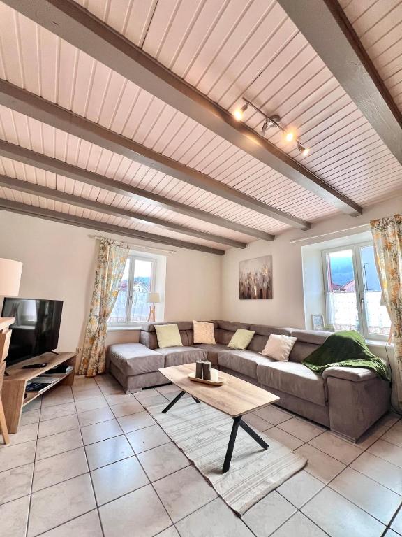 un salon avec un canapé et une table dans l'établissement L'escapade Vosgienne, à Cornimont