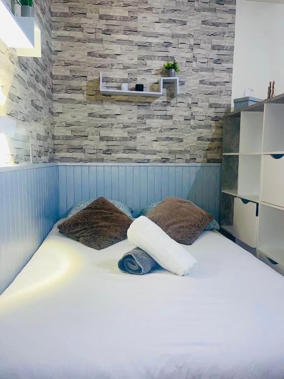 - un lit avec deux oreillers et un mur en briques dans l'établissement Studio pour 2 personnes, à Dinard