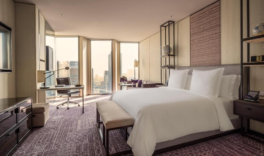 a bedroom with a large white bed and a desk at Four Seasons Hotel Seoul in Seoul