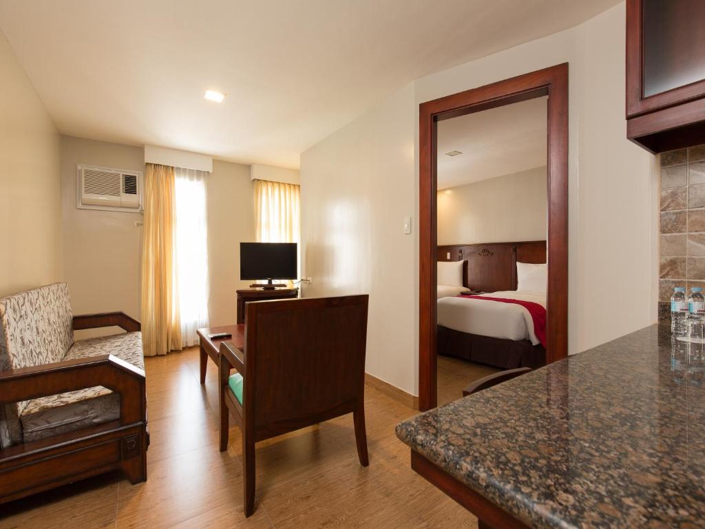 a hotel room with a bedroom with a bed at MJ Hotel and Suites in Cebu City