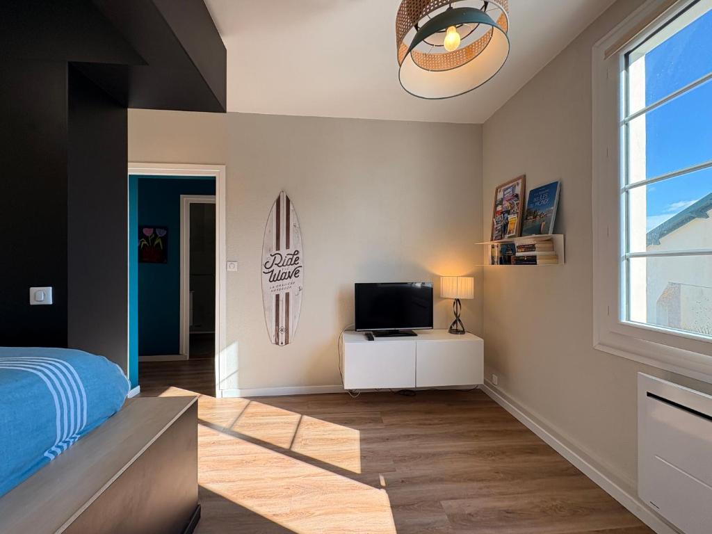 une chambre avec un lit, une télévision et une fenêtre dans l'établissement Apartment Erretegia, à Capbreton