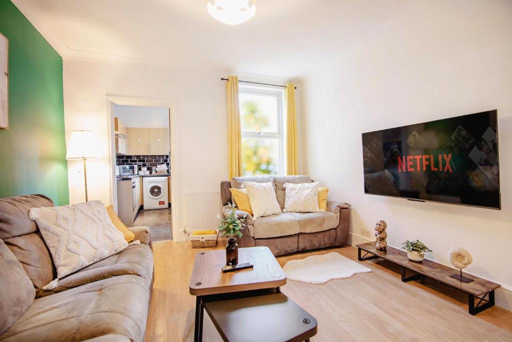 ein Wohnzimmer mit Sofa und Tisch in der Unterkunft Central Urban Retreat Oasis Free Parking 13ppl in Sheffield
