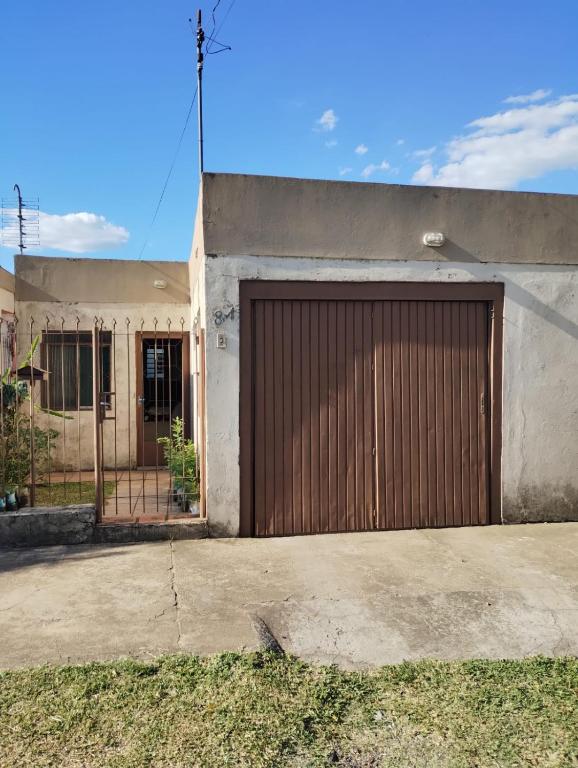 a building with a brown garage door on it at Residência do Roberto in Rosário do Sul