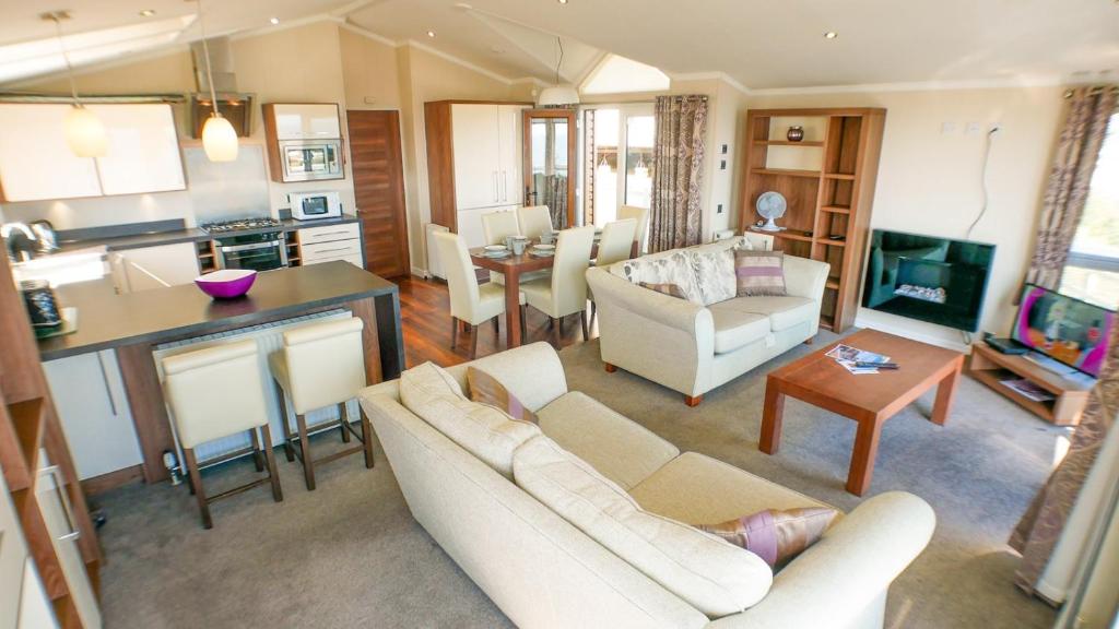 a living room with a couch and a table at 3 Bed 2 Bathroom Super Lodge! Sea Views! in Exmouth