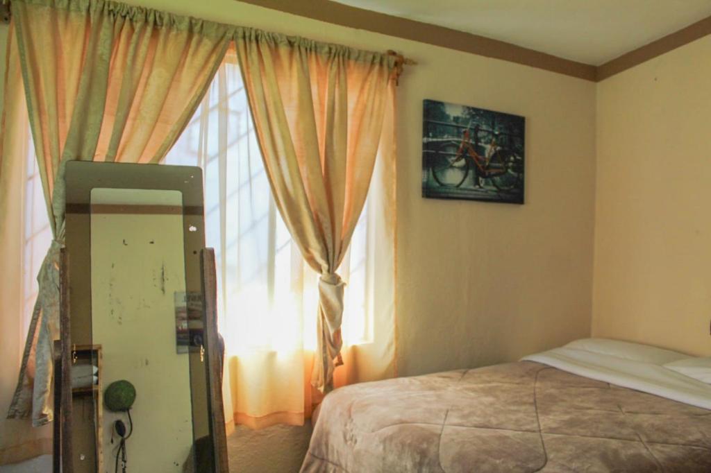 Los AranaにあるHospedajeRancholajoya-Habitacion Fresnoのベッドと窓のある寝室