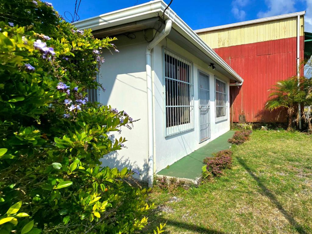a house with a red and white building at Casa Cattleya - Monteverde, Costa Rica in Monteverde Costa Rica