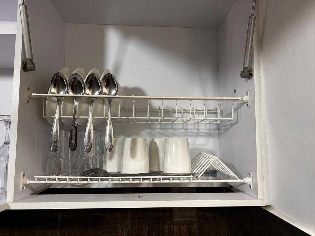 an open refrigerator with utensils on a shelf at Apartamento centro 602 in Medellín
