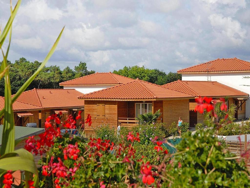 Une rangée de maisons avec des fleurs rouges au premier plan dans l'établissement Cassen Holiday House with Pool, à Cassen