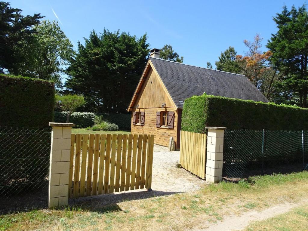 una valla de madera delante de una casa en Wooden House by Beach near Barneville, en Denneville