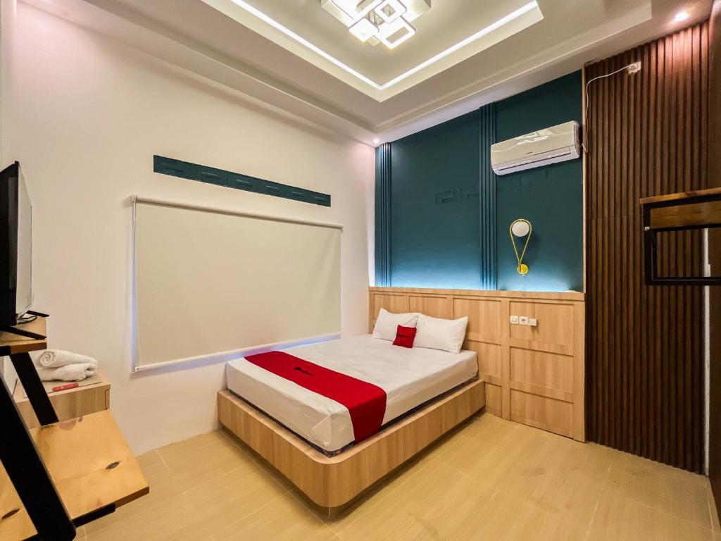 a bedroom with a bed and a blue wall at RedDoorz Near Alun Alun Blitar in Karangtengah