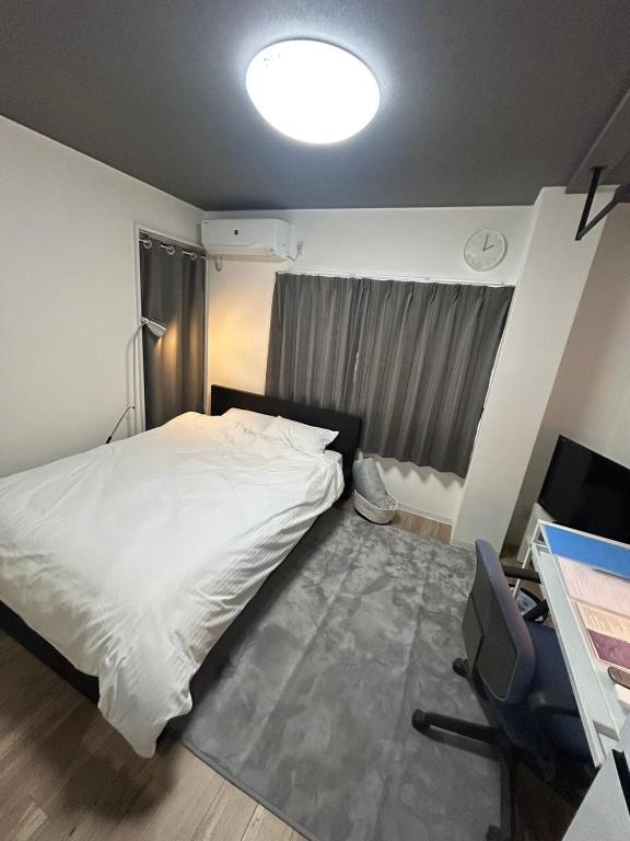 a bedroom with a bed and a desk with a computer at SABBATH uzumasa 102 in Kyoto