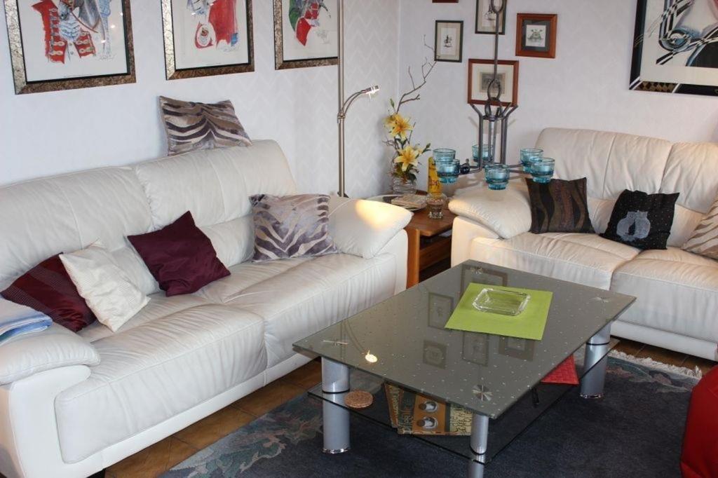 a living room with two white couches and a table at Ferienhaus 008 in Tossens in Stick