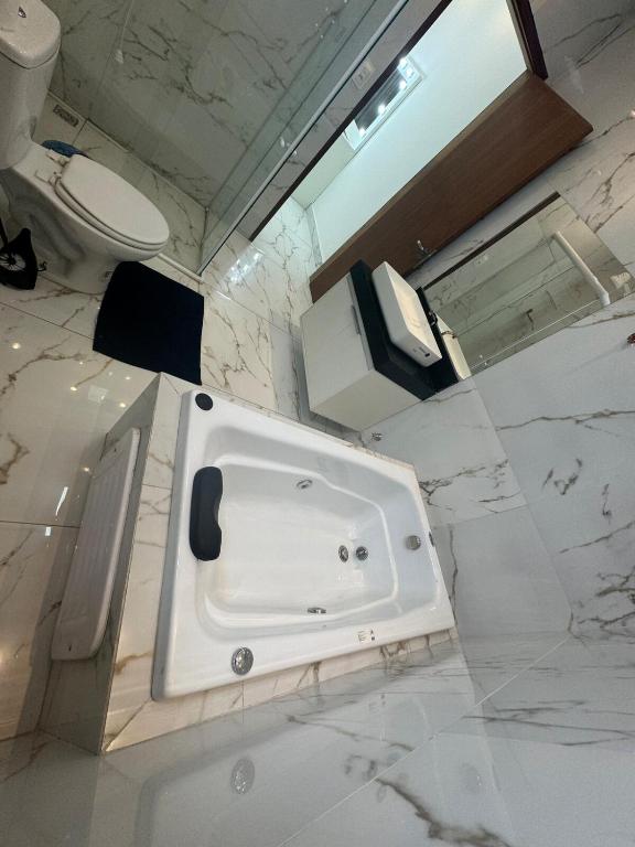 a white bathroom with a sink and a toilet at Casa moderna Malvinas in Campina Grande