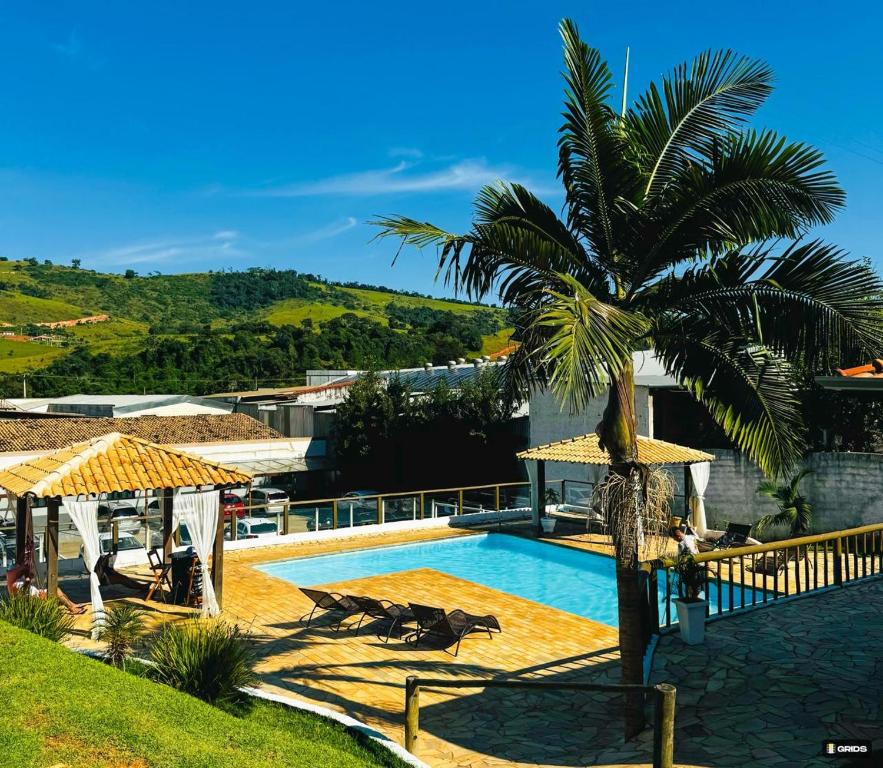 una villa con palmera y piscina en Prime Garden Pousada, en Socorro