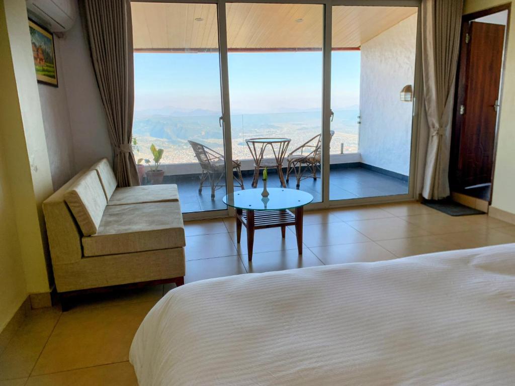 um quarto com uma cama, uma mesa e cadeiras em Superview Lodge, Best Himalayan Sunrise in Sarangkot em Pokhara
