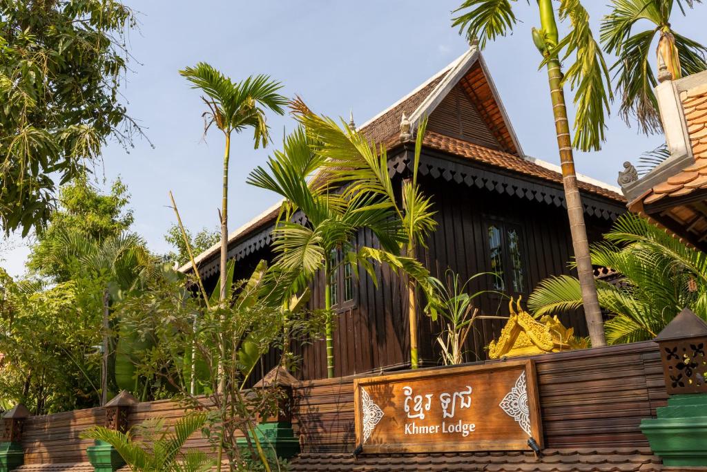 a house with palm trees in front of it at Khmer Lodge in Phumĭ Réach Born (2)