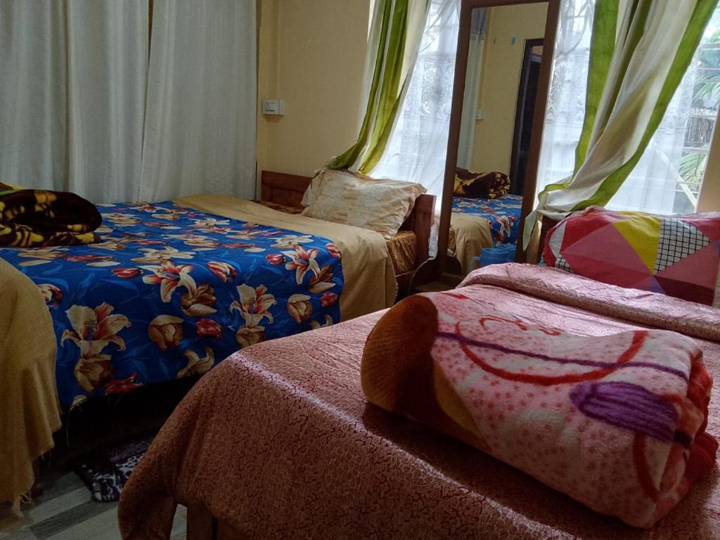 a room with three beds and a mirror at Pt khongknaw homestay in Mawlynnong