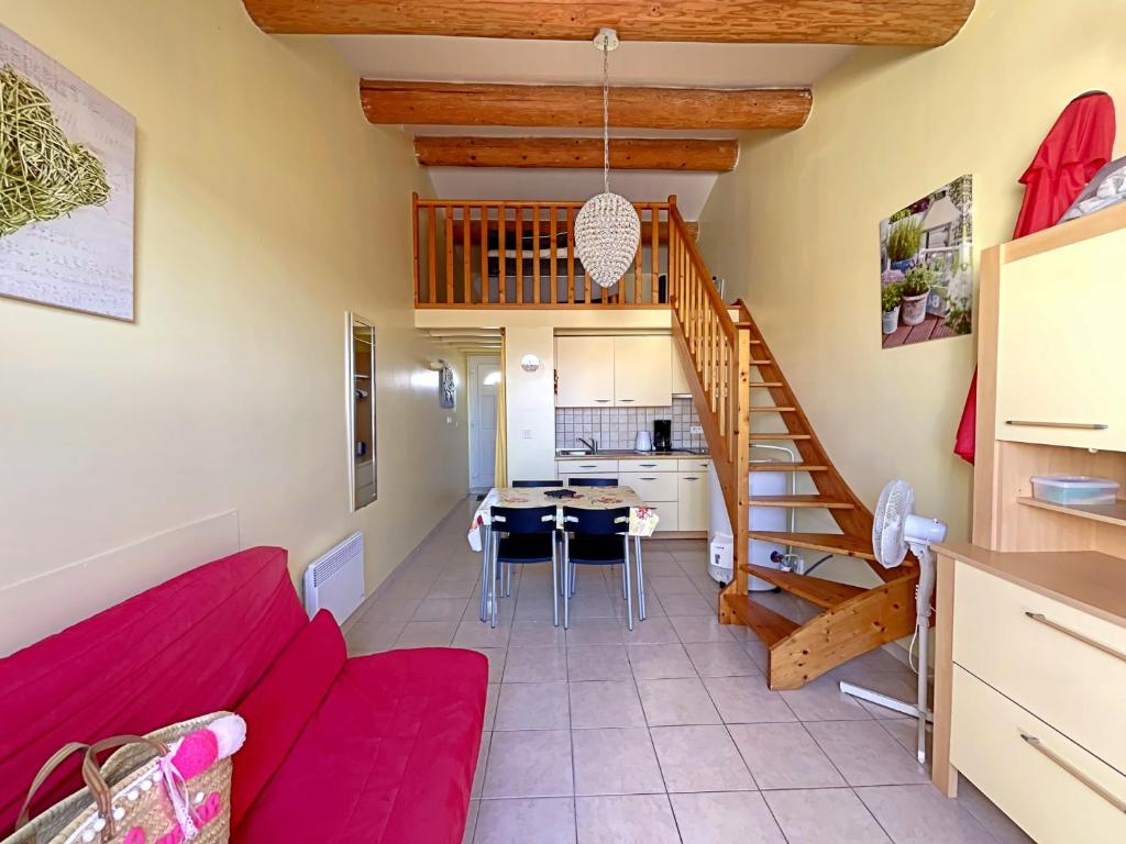 un salon avec un canapé rouge et une cuisine dans l'établissement Appartement 4 pers avec vue mer, climatisé, aux Saintes-Maries-de-la-Mer - FR-1-475-212, à Saintes-Maries-de-la-Mer