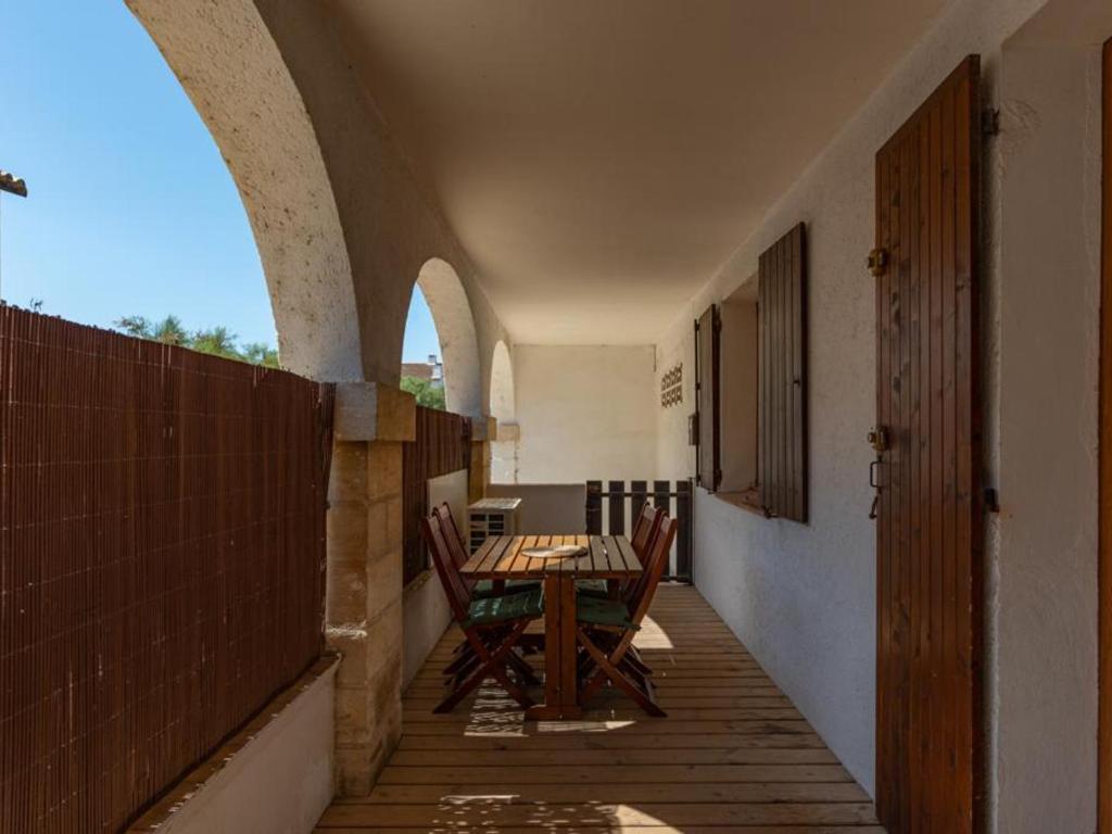 an empty hallway with a table and chairs on a balcony at Appartement RDC rénové, 4 pers, climatisation - FR-1-475-209 in Saintes-Maries-de-la-Mer