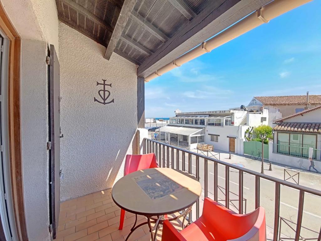 un balcon avec une table et des chaises et une vue dans l'établissement Duplex rénové avec climatisation près de la mer - FR-1-475-213, à Saintes-Maries-de-la-Mer