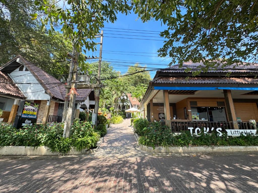 a street in a town with buildings and trees at Tok Little Hut in Rayong
