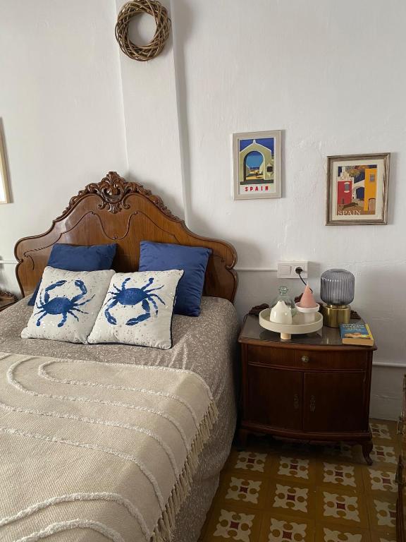 a bedroom with a bed with blue pillows and a table at Casa Carmen Oliva Townhouse in Oliva