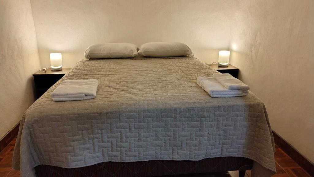 a bedroom with a bed with two pillows on it at Casa Café in San Lucas Tolimán