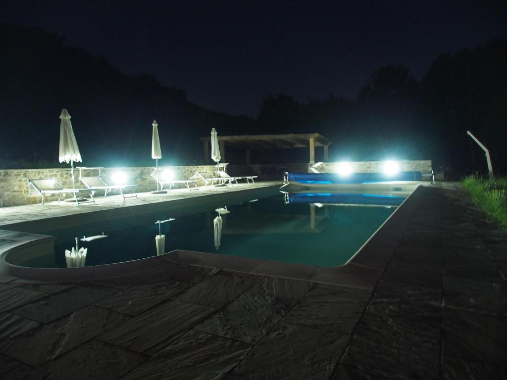 a swimming pool at night with lights at Il Giardino Di Rosmarino in Pontremoli