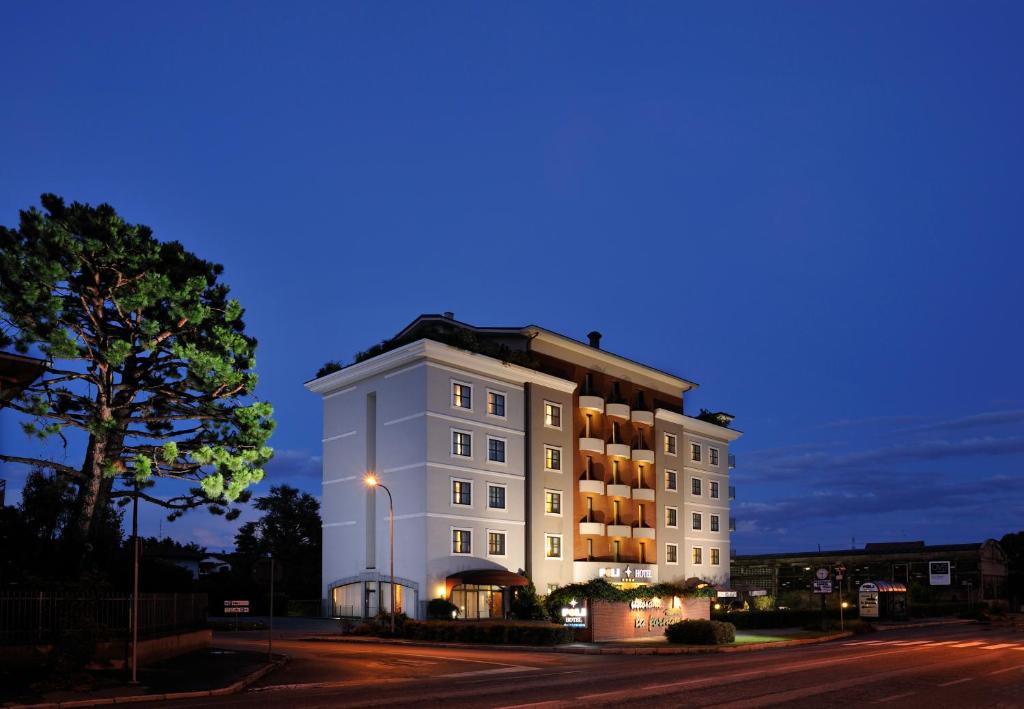 a large white building on a street at night at Poli Hotel in San Vittore Olona