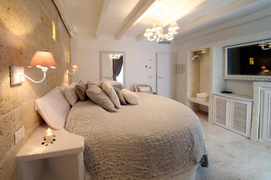 a bedroom with a bed with pillows on it at Playa del Mar - Adults Only in Monopoli