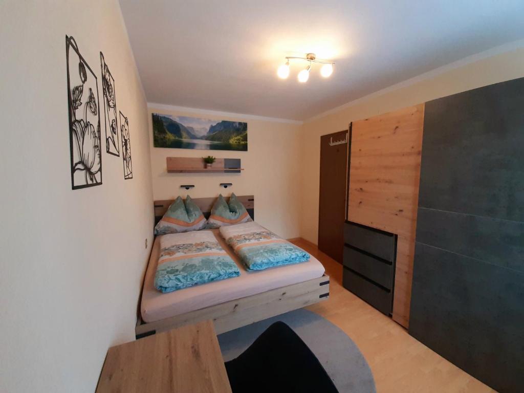 une petite chambre avec un lit et une télévision dans l'établissement Susis Apartment Altenmarkt, à Altenmarkt im Pongau