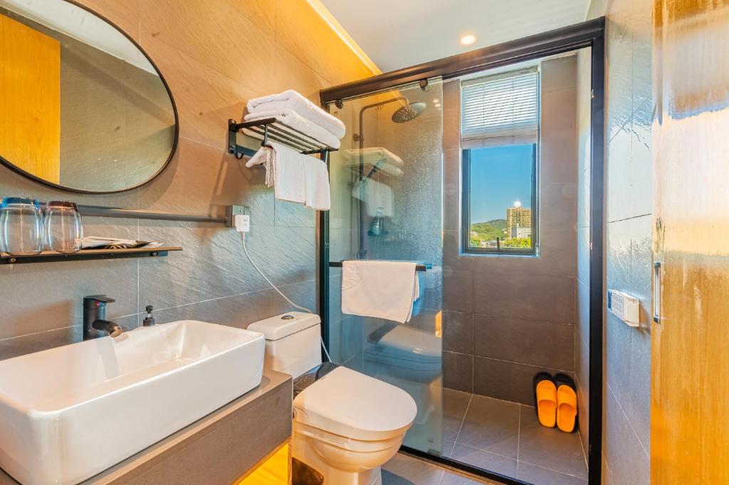 un bagno con lavandino, wc e doccia di Shenzhen Yusu Linting Seaview Inn Judiaosha Branch a Shenzhen